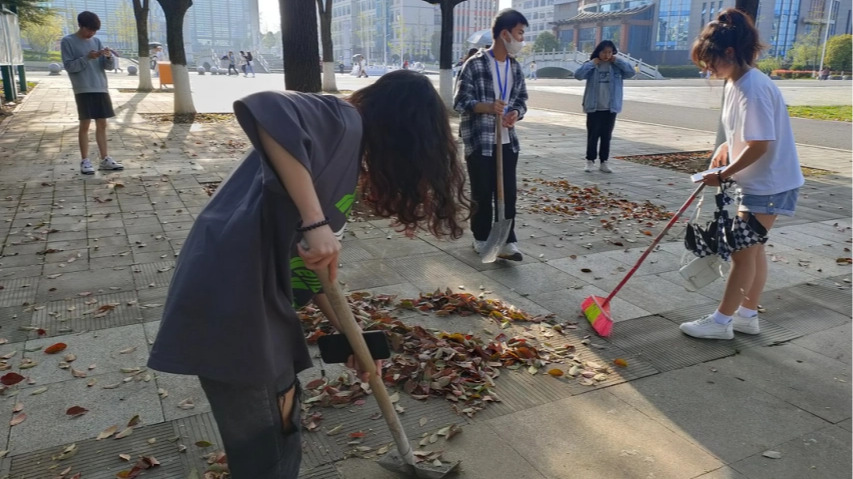 同学们拿起劳动工具进行清扫.jpg